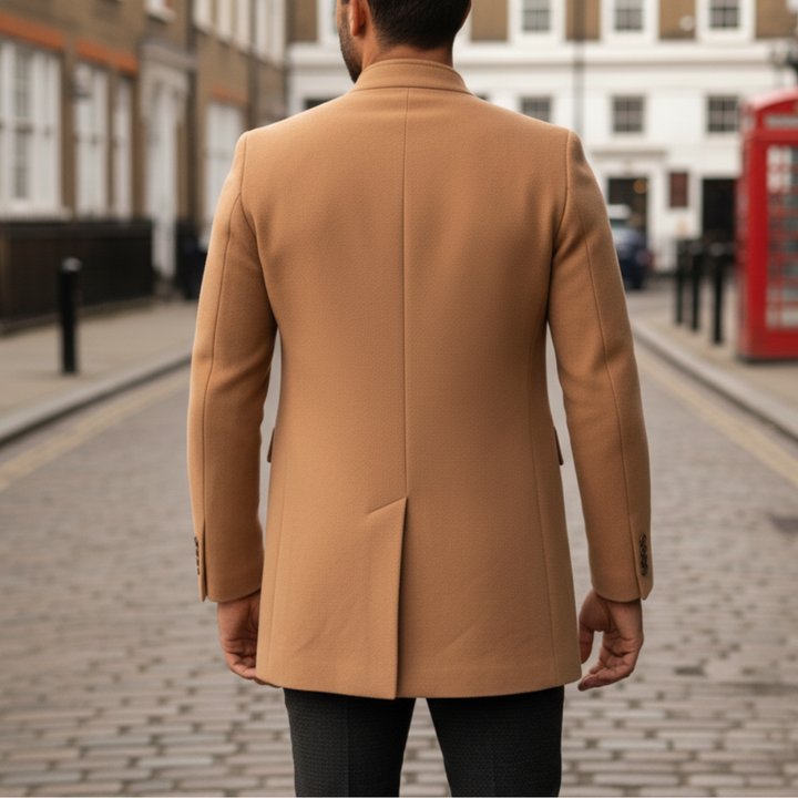 Brown coat back details over a white textured polo and dark pants. The man left hand adjusts the coat.