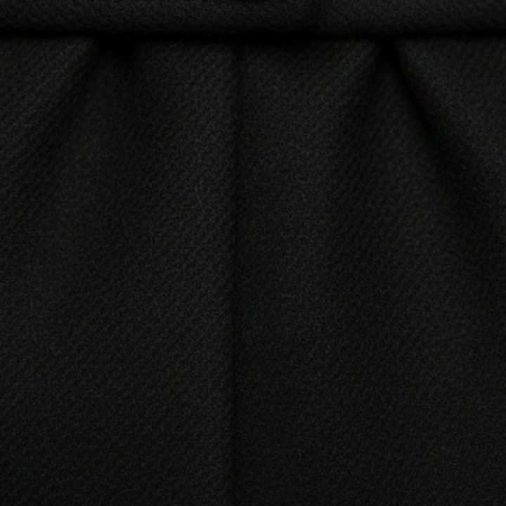 A woman in a long, tailored coat with a notched lapel, standing on a cobblestone street, exuding effortless sophistication.

