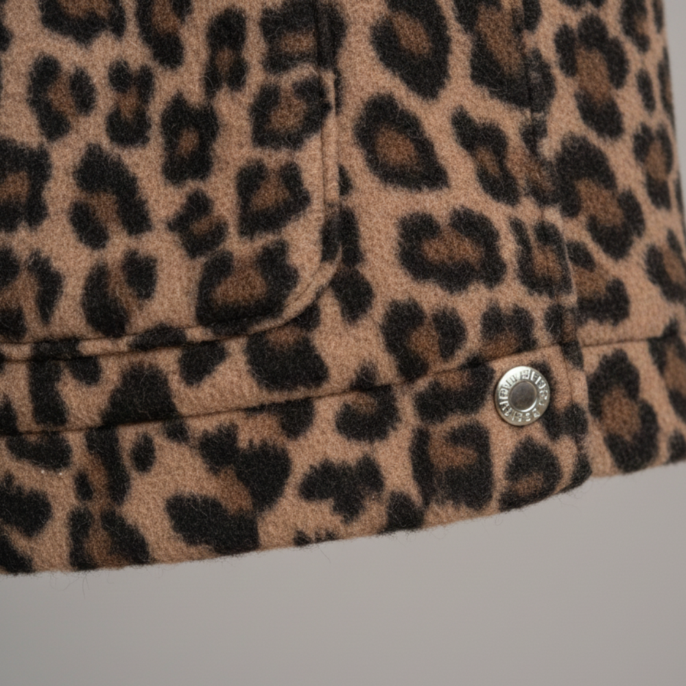 A woman models a leopard print quilted jacket with long sleeves and practical pockets, good for casual layering.
