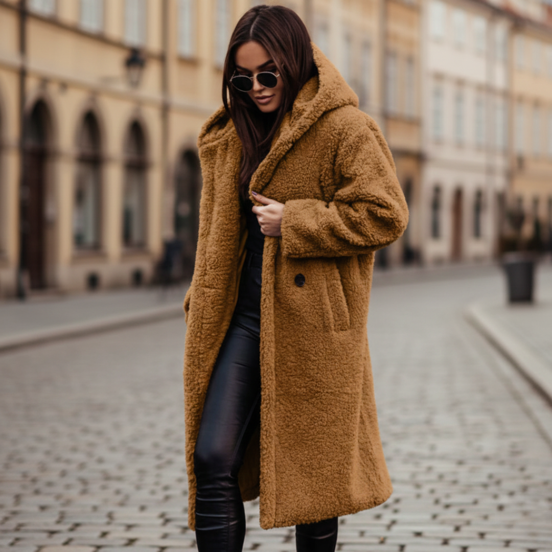A woman wearing a brown hooded coat and black pants, showcasing a cozy and stylish fall outfit.