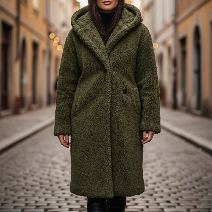 A woman wearing a green hooded coat paired with black pants, showcasing a cozy and stylish fall outfit.