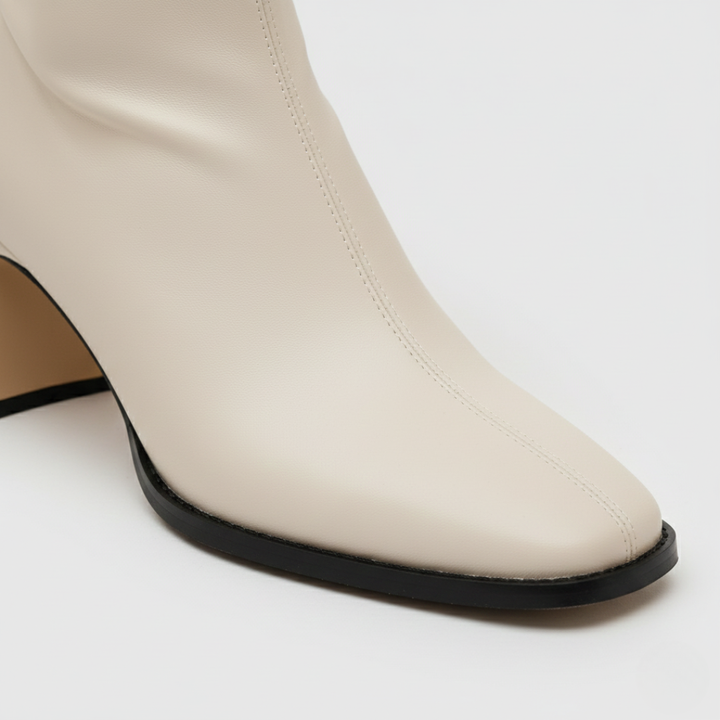 white ankle boots with a square toe on a cobblestone street