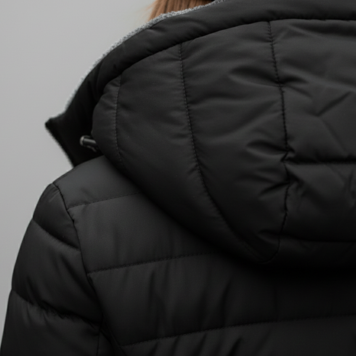 Back detailed look of a black puffer coat, featuring a hood and structured quilting, ideal for fall and winter outings.