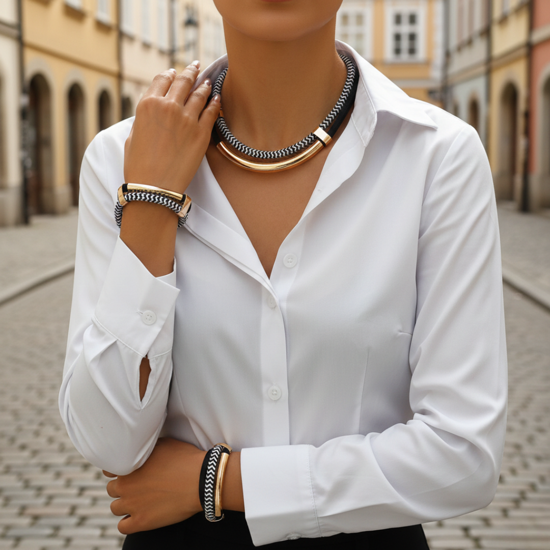 A close-up of a woman's hand adorned with a gold and black bracelet, showcasing modern elegance and style.