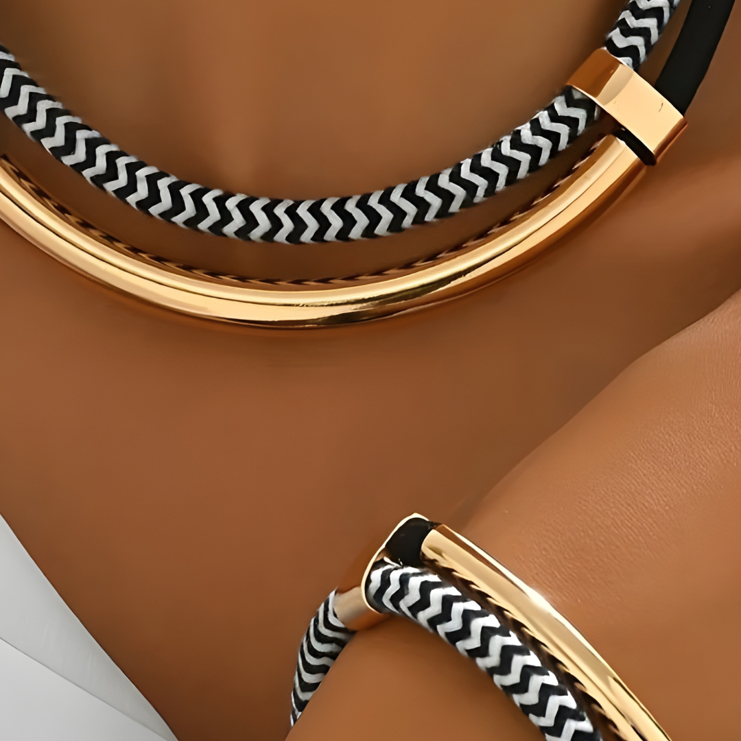 A close-up of a woman's hand adorned with a gold and black bracelet, showcasing modern elegance and style.