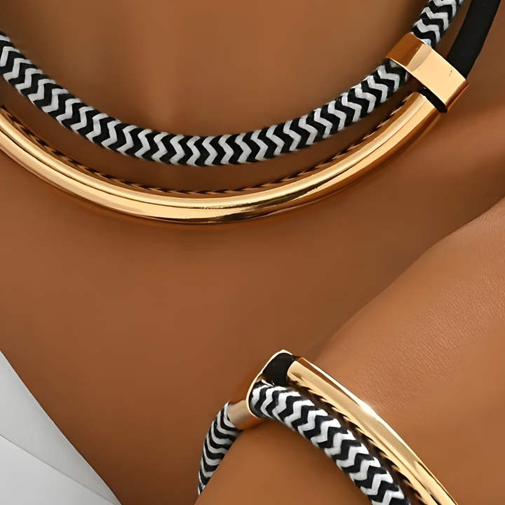 A close-up of a woman's hand adorned with a gold and black bracelet, showcasing modern elegance and style.