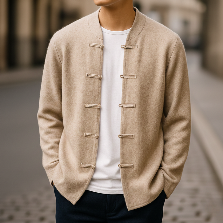 A man wearing a beige jacket stands on a street, featuring a clean silhouette and long sleeves, good for transitional weather.