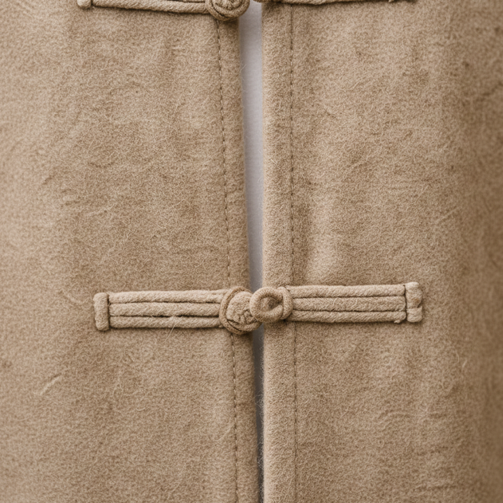 A man wearing a beige jacket stands on a street, featuring a clean silhouette and long sleeves, good for transitional weather.