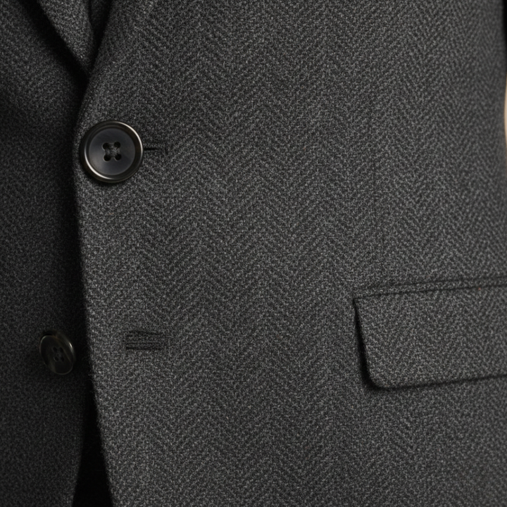 Close-up details of the tailored three-piece suit stands confidently on a cobblestone street, showcasing elegance and style