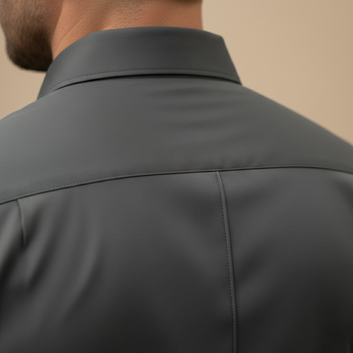 A man wearing a grey button-up shirt and black pants, showcasing a sleek and modern silhouette.