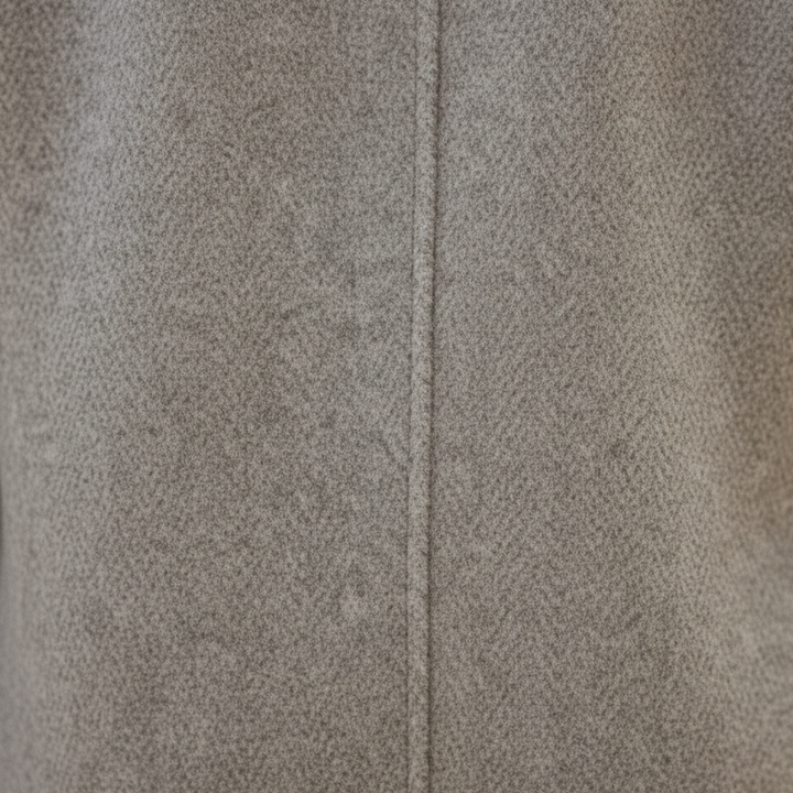 A woman wearing a knee-length double-breasted coat and black pants,  good for fall and winter outings.