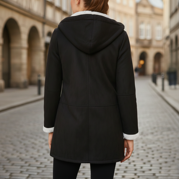Black hooded coat with a white collar and toggle closures, designed for warmth and elegance in fall and winter.