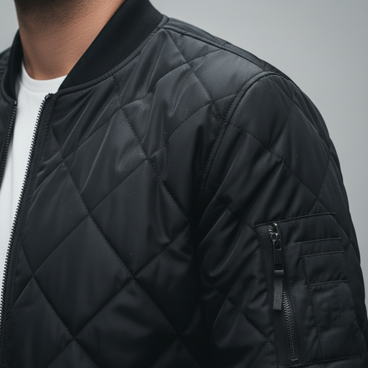 Men's quilted bomber jacket featuring a diamond-stitched finish, zip-front, ribbed neckline in a close-up look. 