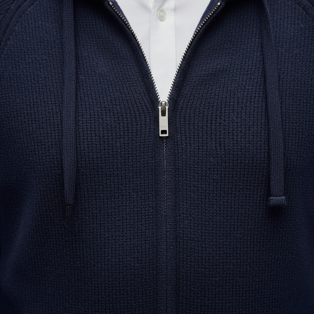 Close-up look of a navy hooded cardigan in ribbed knit, featuring a zip-up front and relaxed fit, ideal for fall and winter layering.
