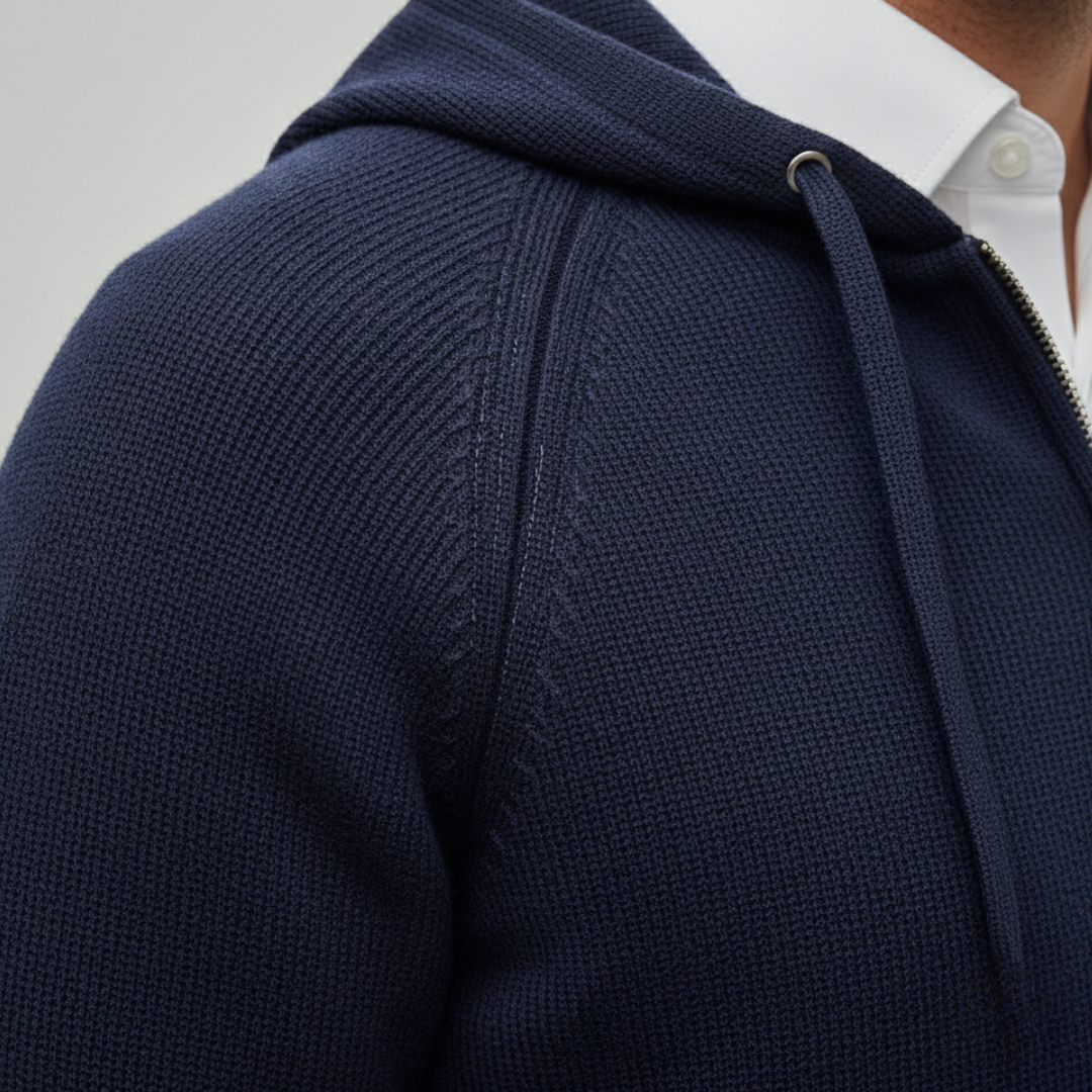 Close-up look of a navy hooded cardigan in ribbed knit, featuring a zip-up front and relaxed fit, ideal for fall and winter layering.