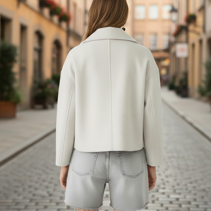 White cropped double-breasted jacket with structured lapels, made from polyester (faux wool), ideal for fall and spring layering.
