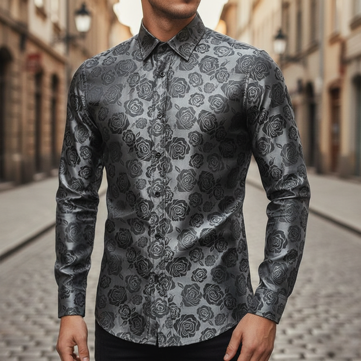 A man wearing a black and silver paisley shirt, showcasing a sophisticated and polished style for evening events.


