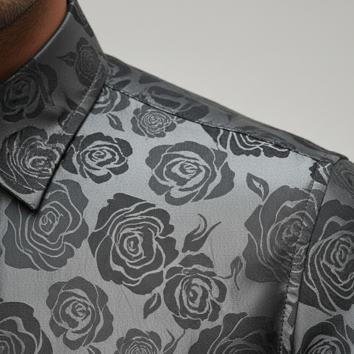 A man wearing a black and silver paisley shirt, showcasing a sophisticated and polished style for evening events.

