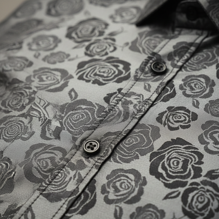 A man wearing a black and silver paisley shirt, showcasing a sophisticated and polished style for evening events.

