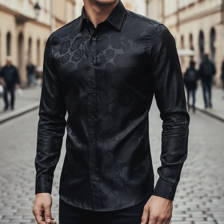 A man wearing a black paisley shirt, showcasing a sophisticated and polished style for evening events.

