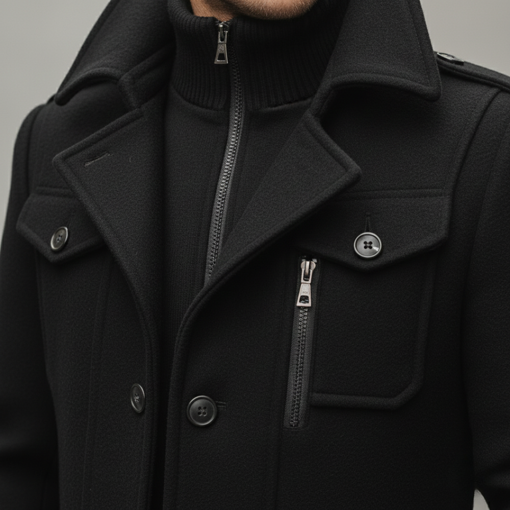 Close-up look of a black mid-length wool coat featuring a hood, turn-down collar, and long sleeves.