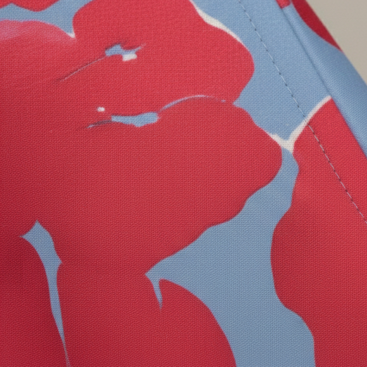 A woman wearing a maxi dress with a red and blue floral design, showcasing a wrap bodice and three-quarter sleeves.