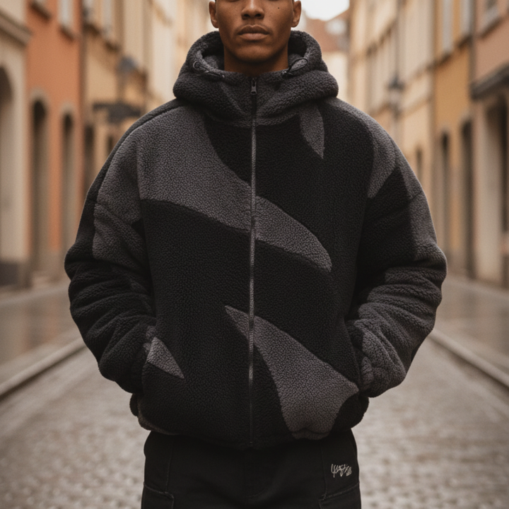  A man in a stylish black and grey fleece jacket with a hood