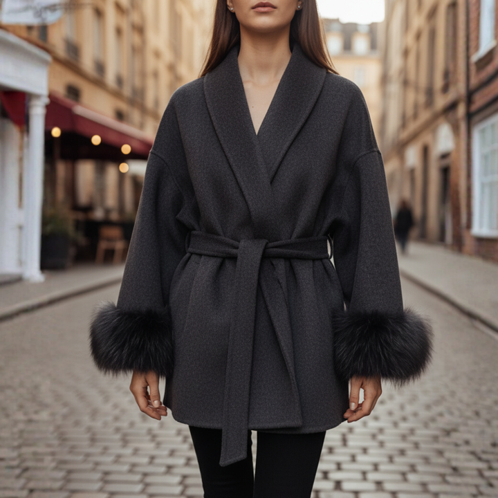 A woman wearing a dark grey belted coat, showcasing autumn elegance and style.