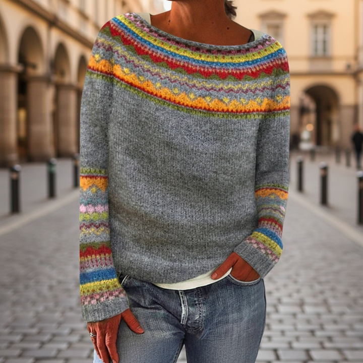 A woman in a colorful striped sweater with a boat neckline, fit for fall and winter.