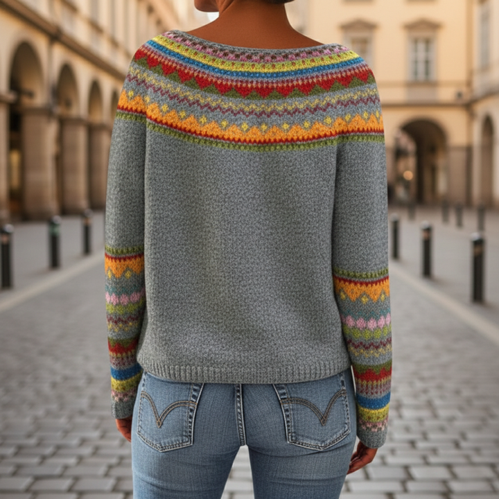 A woman in a colorful striped sweater with a boat neckline, fit for fall and winter.