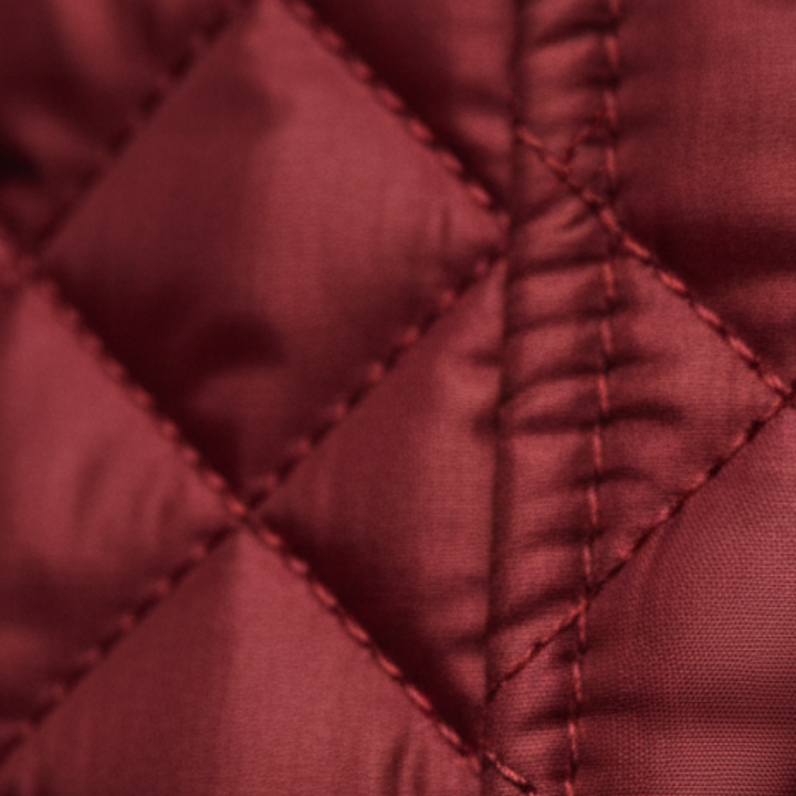red quilted jacket featuring a check collar, ideal for transitional seasons.