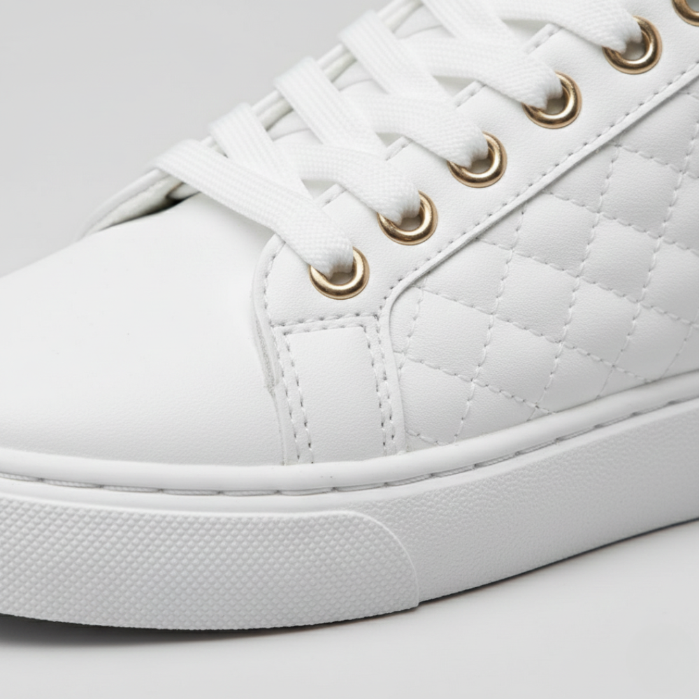 Close-up details of a white sneakers with quilted texture and gold detailing, ideal for casual wear and comfort.