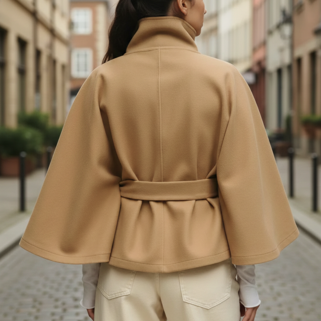 a beige cape jacket over jeans, showcasing a modern and elegant fall outfit with a funnel neckline.