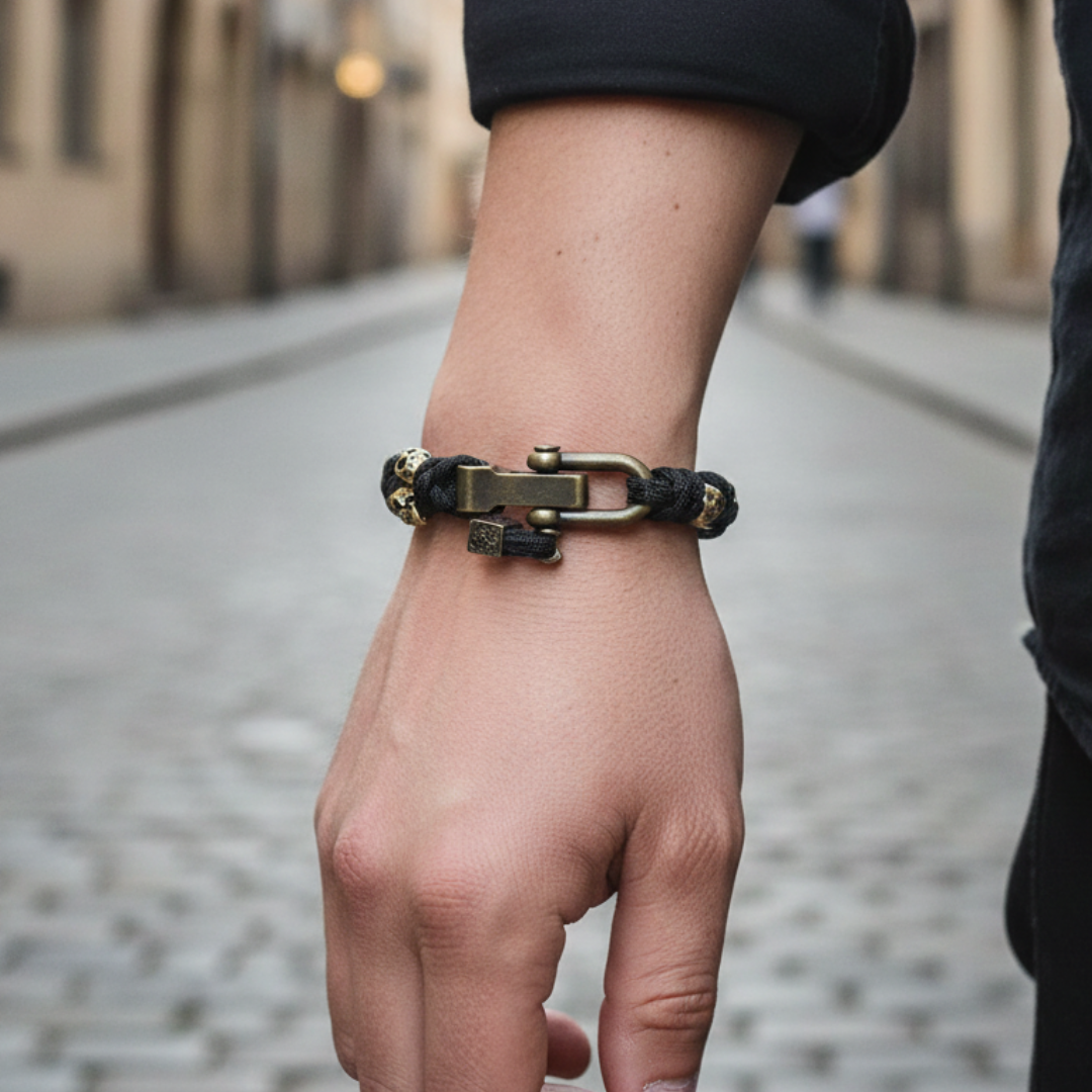 Black paracord bracelet with sculpted skull accents and a metal hook clasp, offering a bold statement for any outfit.