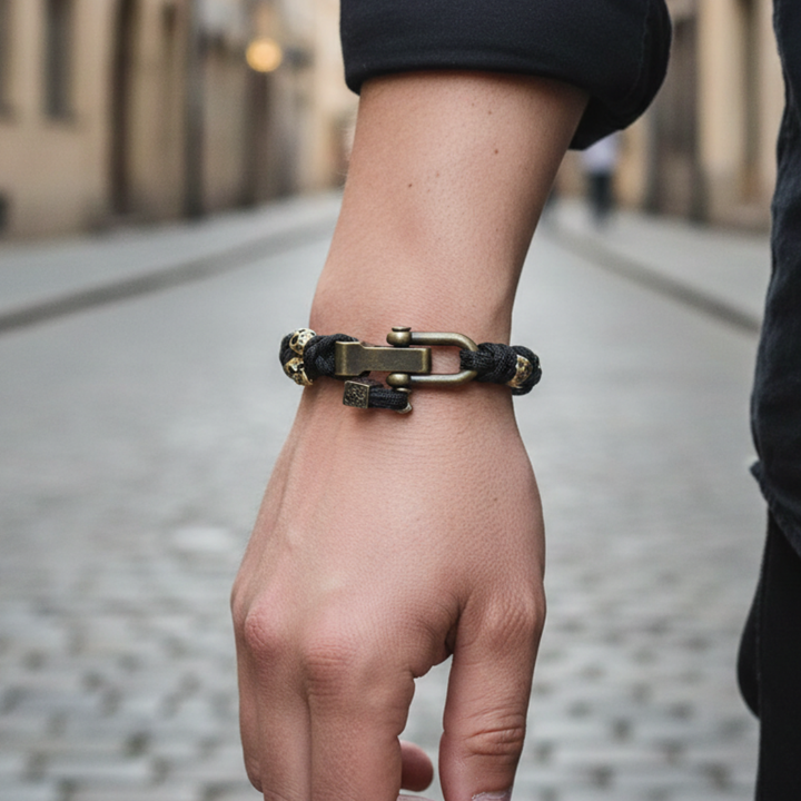 Black paracord bracelet with sculpted skull accents and a metal hook clasp, offering a bold statement for any outfit.