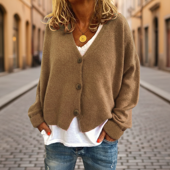  A woman in a beige cardigan sweater, with button-front, showcasing the long sleeves and V-neck, good for fall and spring layering.