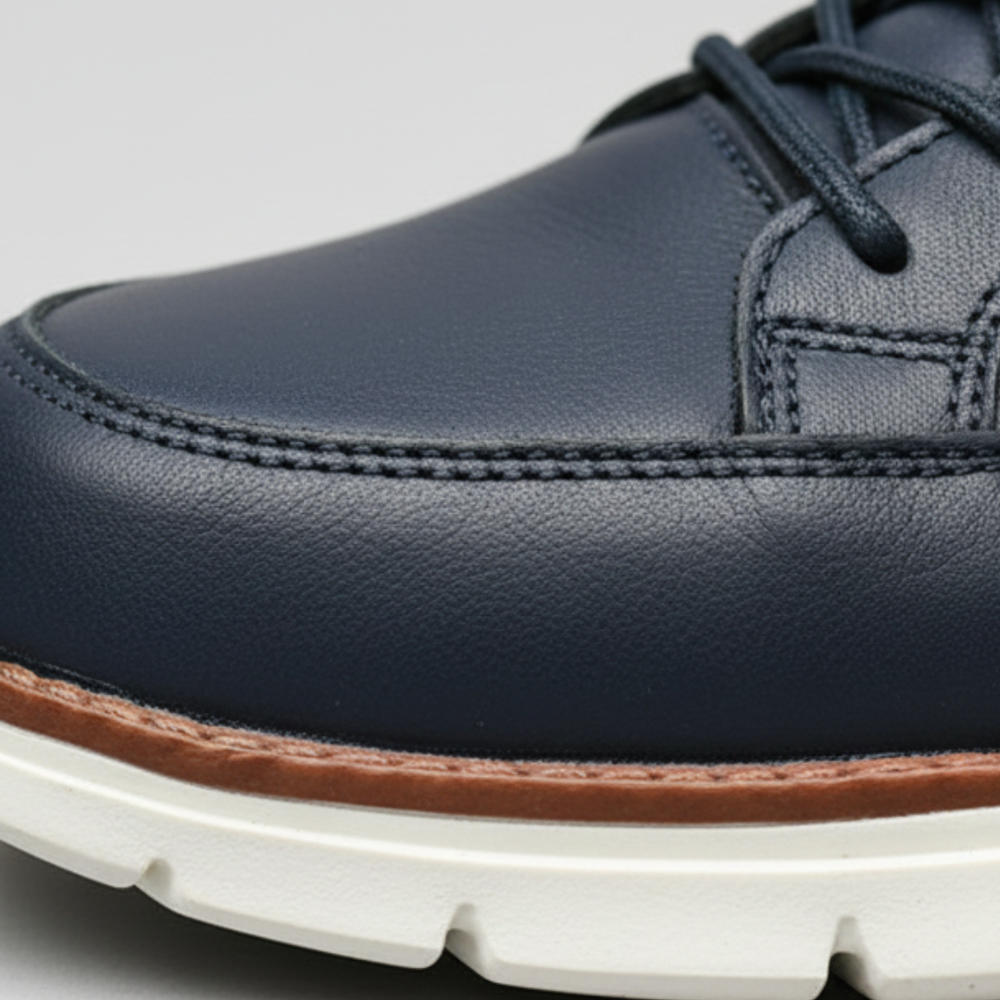 Men's navy leather sneakers with a lace-up design, cushioned sole, and rounded toe.