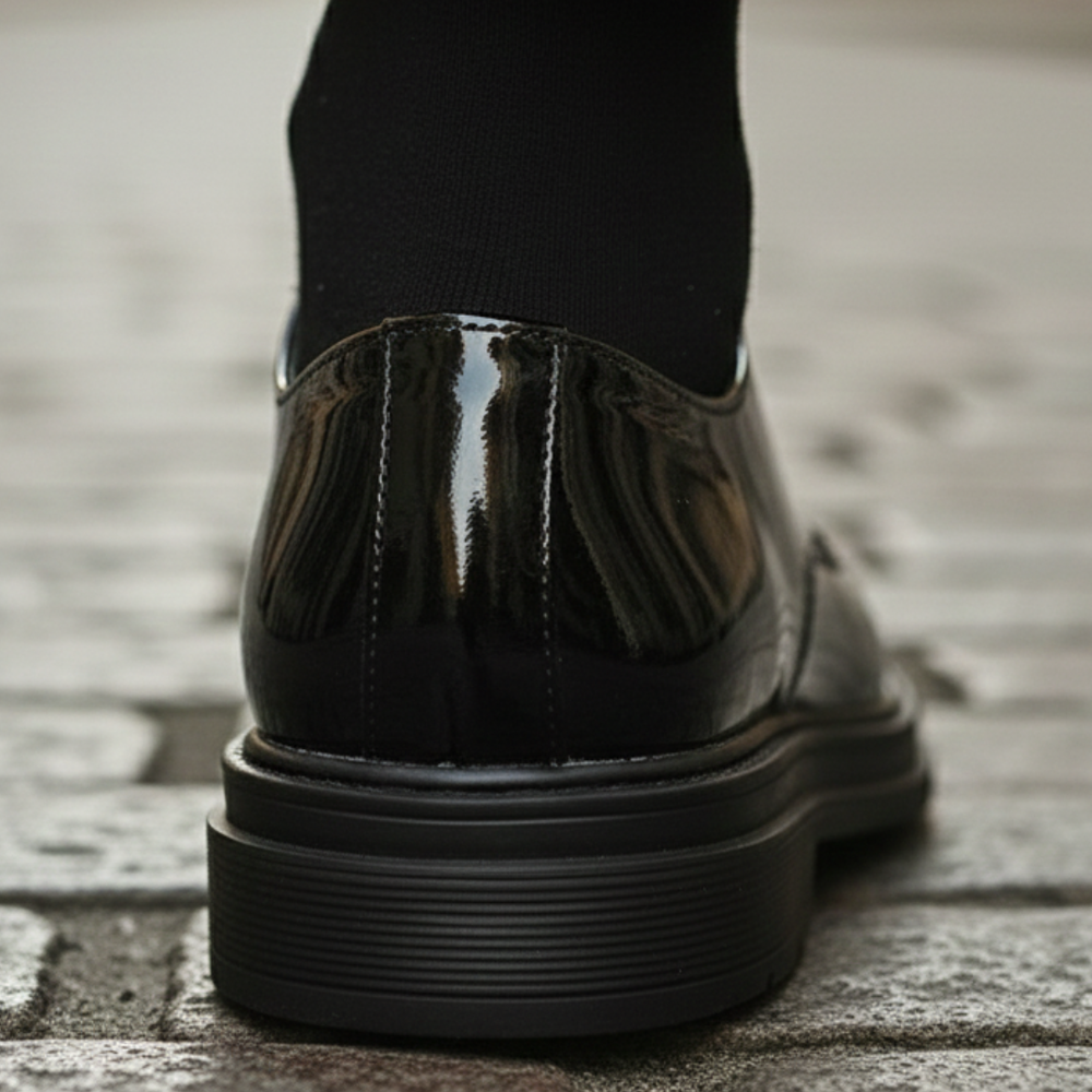 back details of a black suit and polished black shoes, it shows elegance for formal occasions.