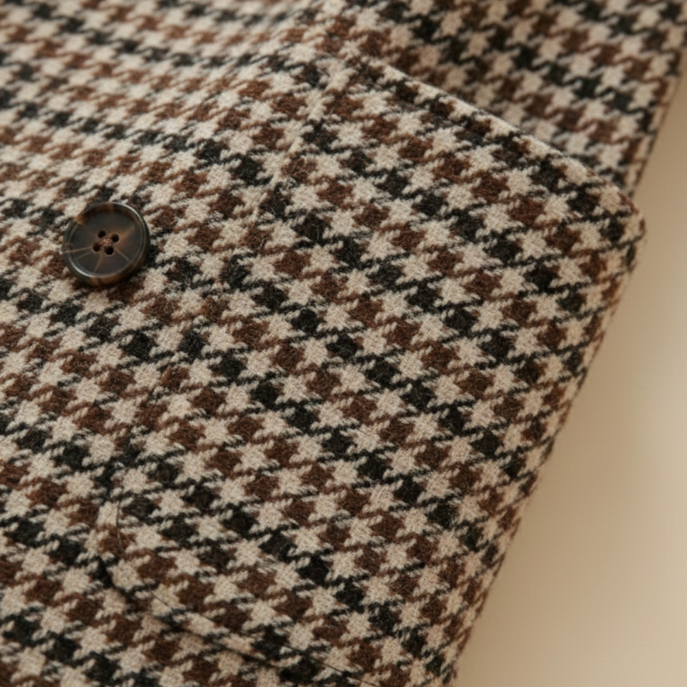 A woman in a checkered blazer and black pants, showcasing a polished, city-ready look for fall and spring.