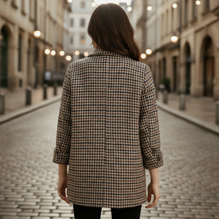 A woman in a checkered blazer and black pants, showcasing a polished, city-ready look for fall and spring.