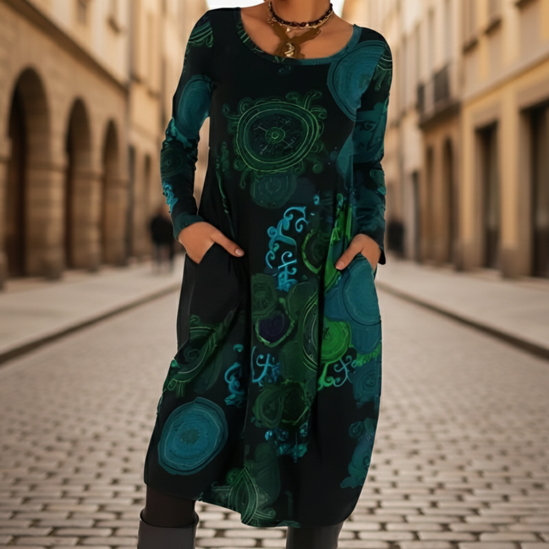 A woman models a midi dress with a  abstract patterns, good for transitional seasons.