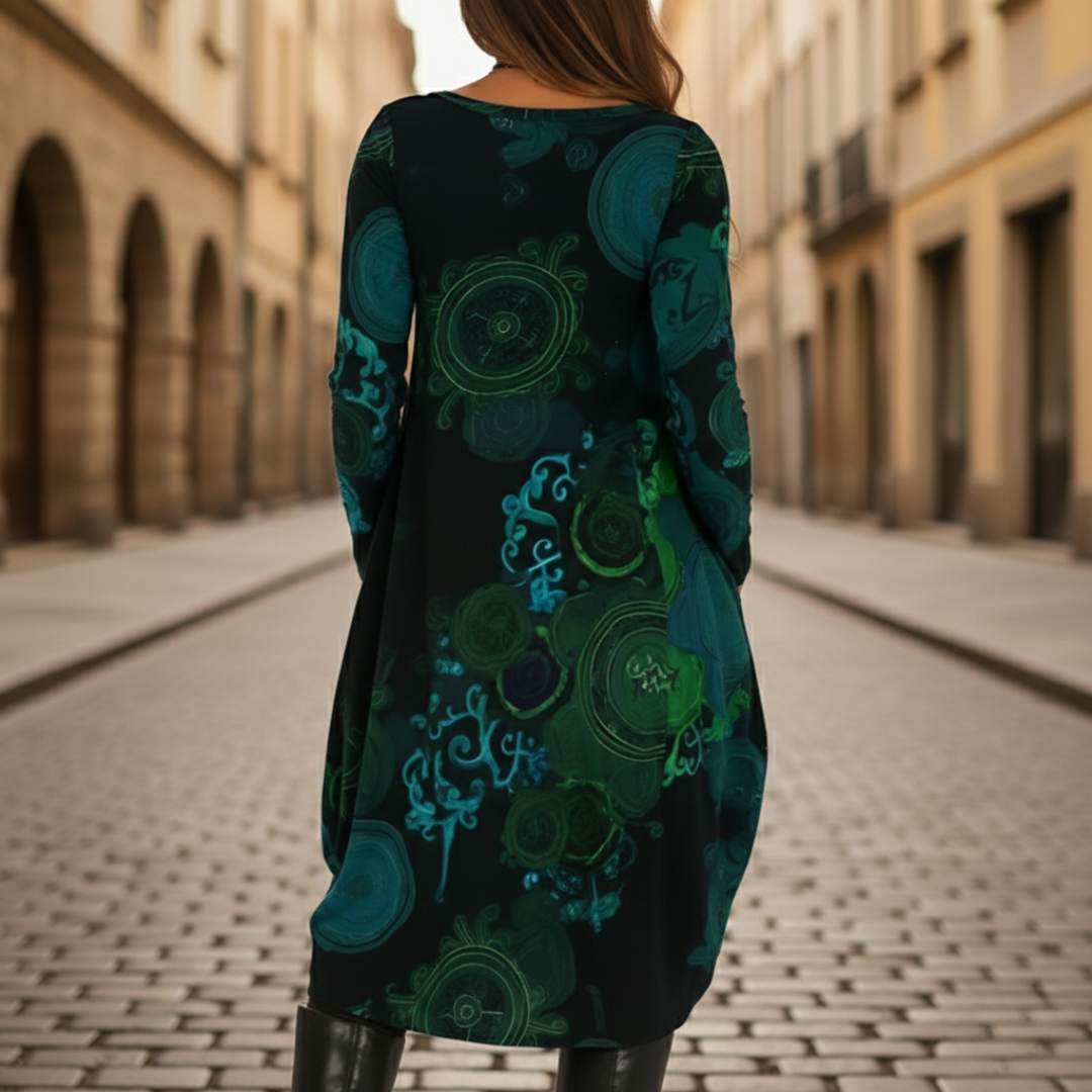 A woman models a midi dress with a  abstract patterns, good for transitional seasons.
