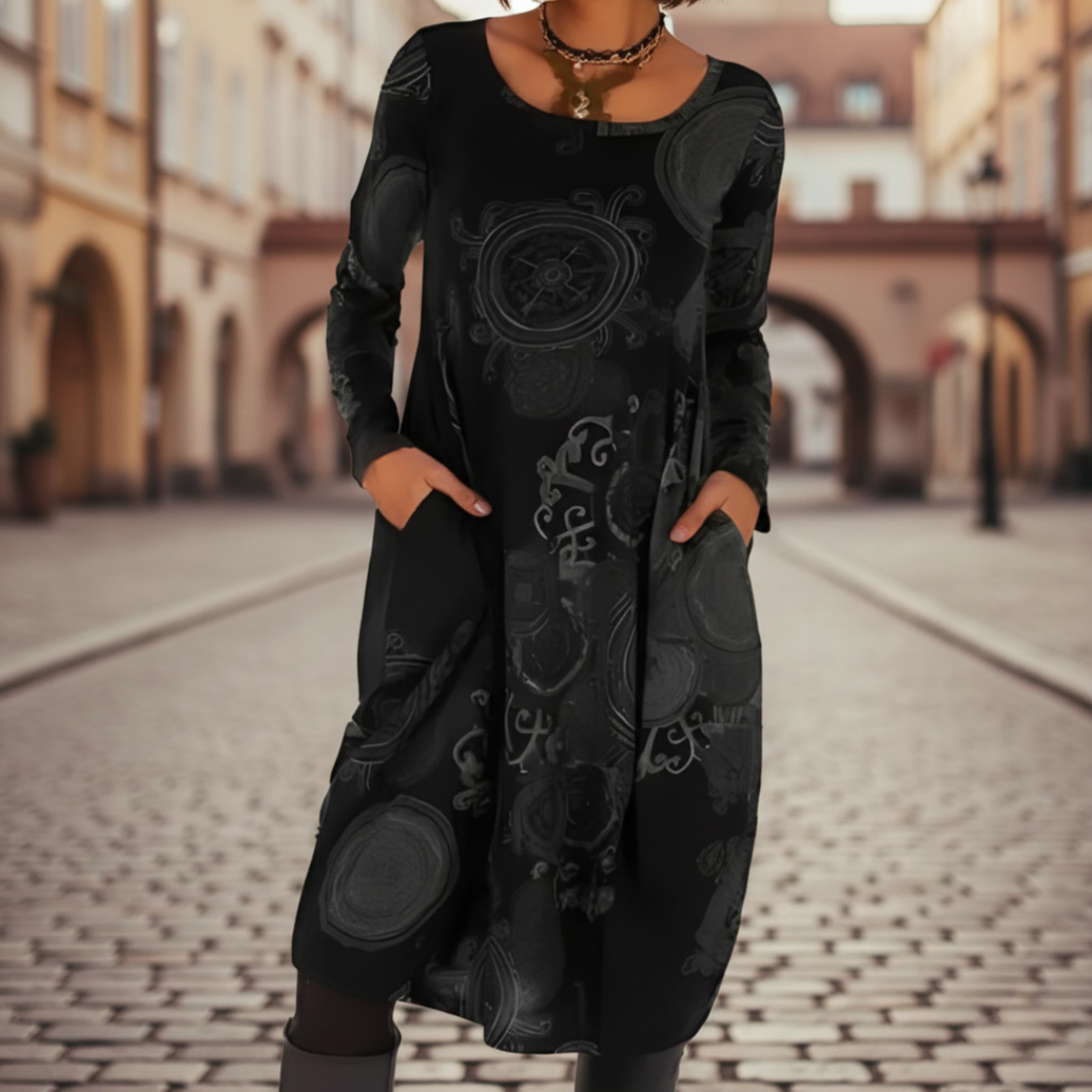 A woman models a midi dress with a  abstract patterns, good for transitional seasons.