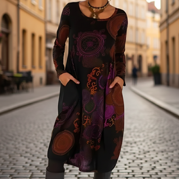 A woman models a midi dress with a  abstract patterns, good for transitional seasons.