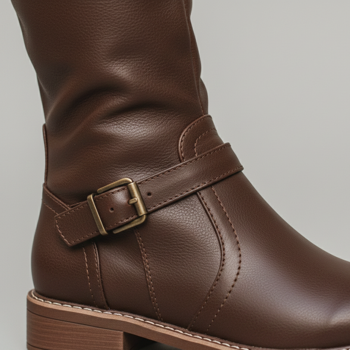 Stylish women's riding boots with buckles, knee-height, and zip closure, ideal for transitional dressing in fall and spring.