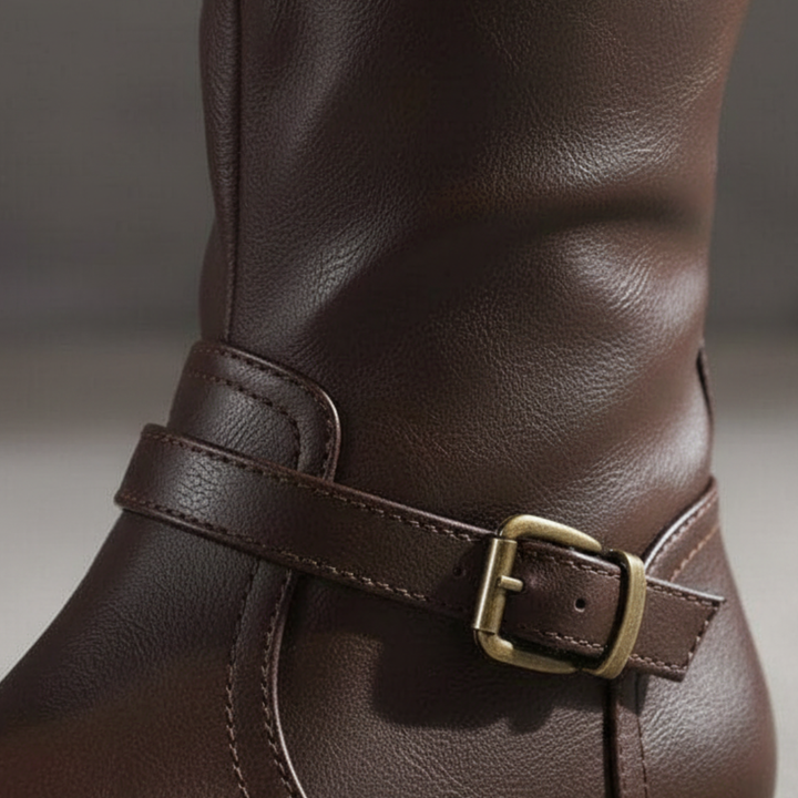 Stylish women's riding boots with buckles, knee-height, and zip closure, ideal for transitional dressing in fall and spring.