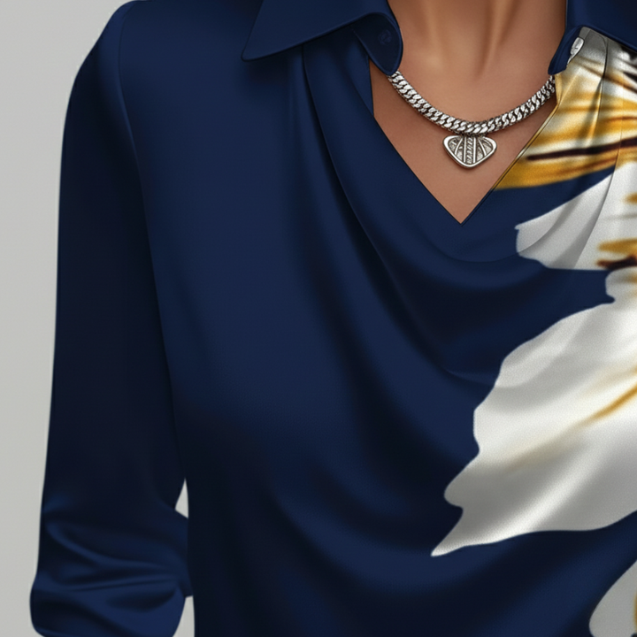 Close-up details of a woman in a blue blouse with yellow flowers, featuring a cowl neckline and long sleeves.