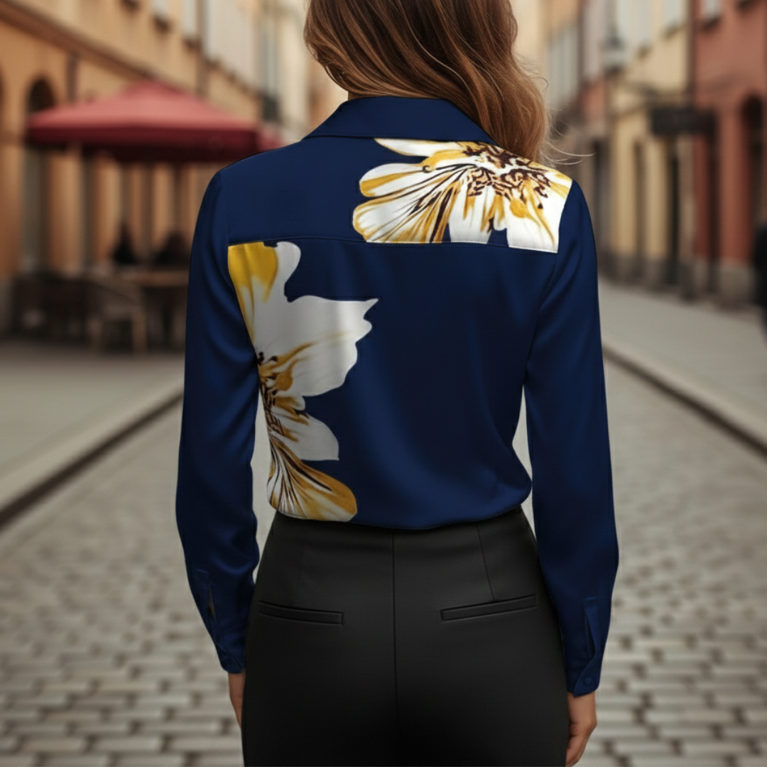 Back details of a woman in a blue blouse with yellow flowers, featuring a cowl neckline and long sleeves.