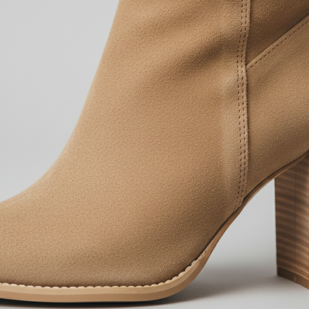 Brown knee-high boots with a side zipper, showcasing modern sophistication and a chunky block heel.