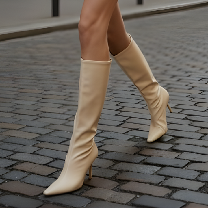 sleek white knee-high boots with a pointed toe and elegant stiletto heel.